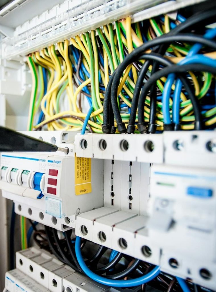 Photo by Pixabay Manitas M.A San Javier - Hand of electrician working on a circuit breaker panel with colorful wires, ensuring safe electrical connections.